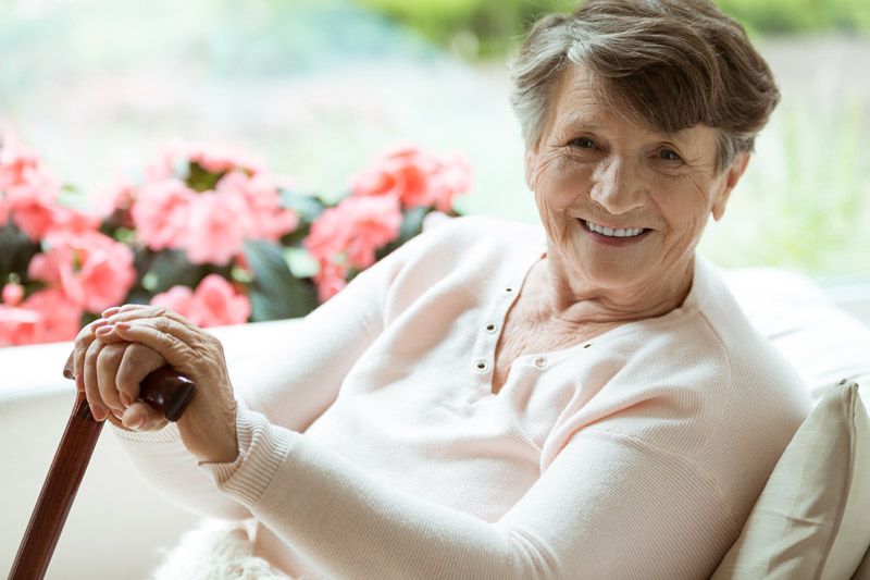 woman-with-walking-stick-smiling-2021-08-26-15-43-07-utc